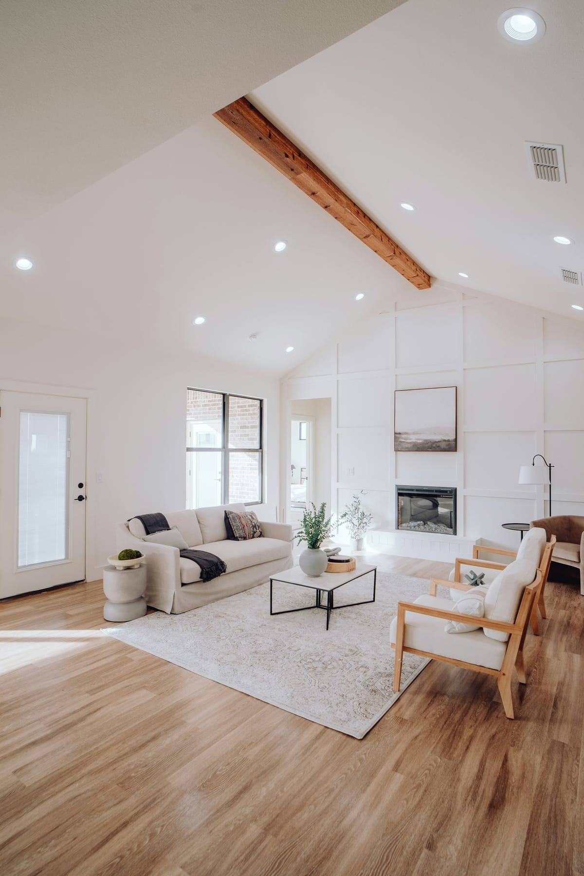 Empty bright living room with vaulted ceiling and white walls